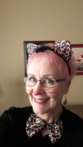 Jackie Foskett smiling in a playful cat costume for Halloween
